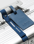 Close-up of a luxury travel case handle with a blue leather tag from the Dallas Cowboys Time Capsule by AIDAN.