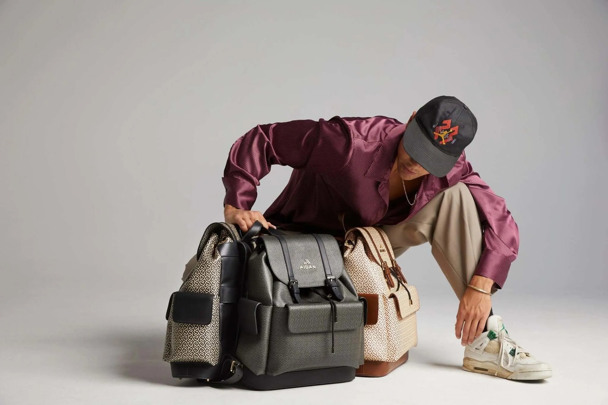 Person examining a variety of stylish backpacks, showcasing Coachella essentials with a modern fashion sense.
